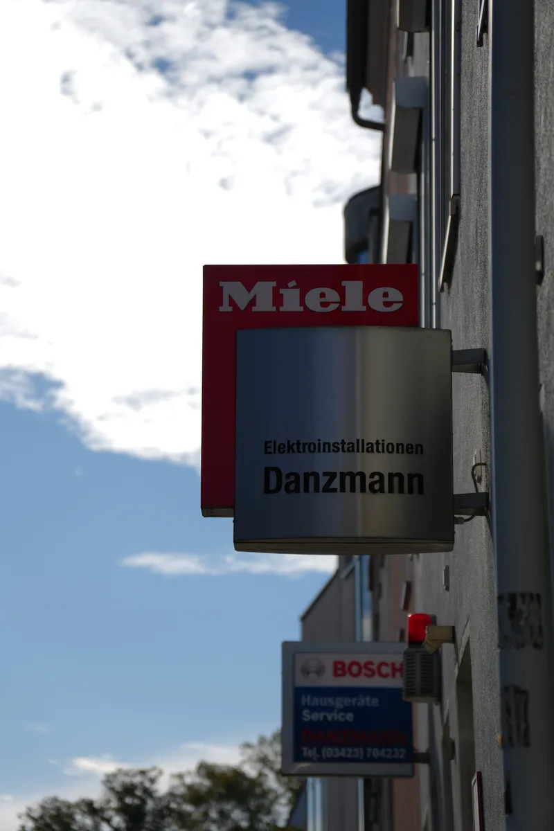 Ladenschild von Danzmann mit Miele- und Bosch-Schild an der Fassade in der August-Fritzsche-Straße